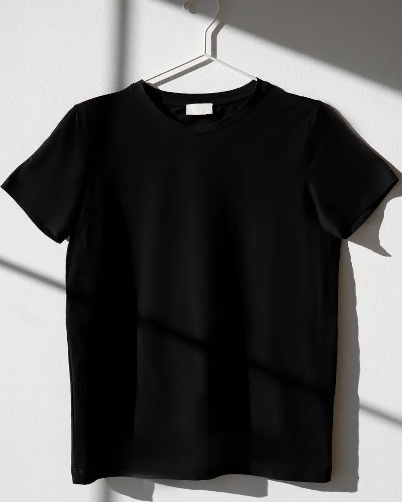 Camiseta preta em cabide branco com sombra artística